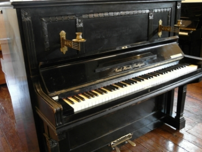 Oude zwarte piano met kandelaars